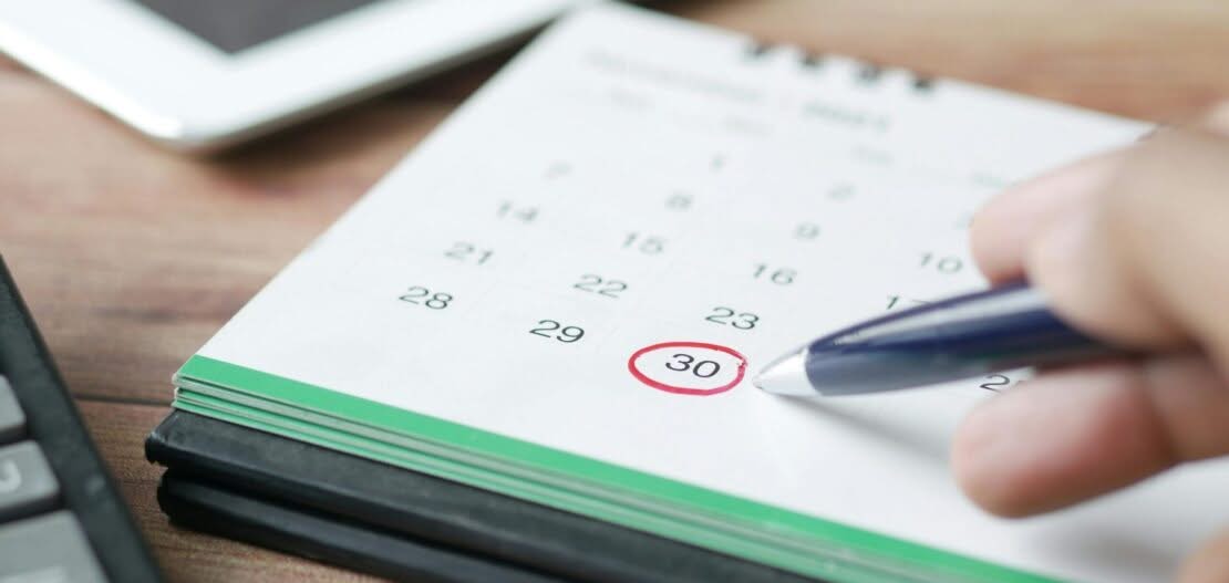 Hand marking calendar date for booking Brilliance Crew cleaning service in San Francisco