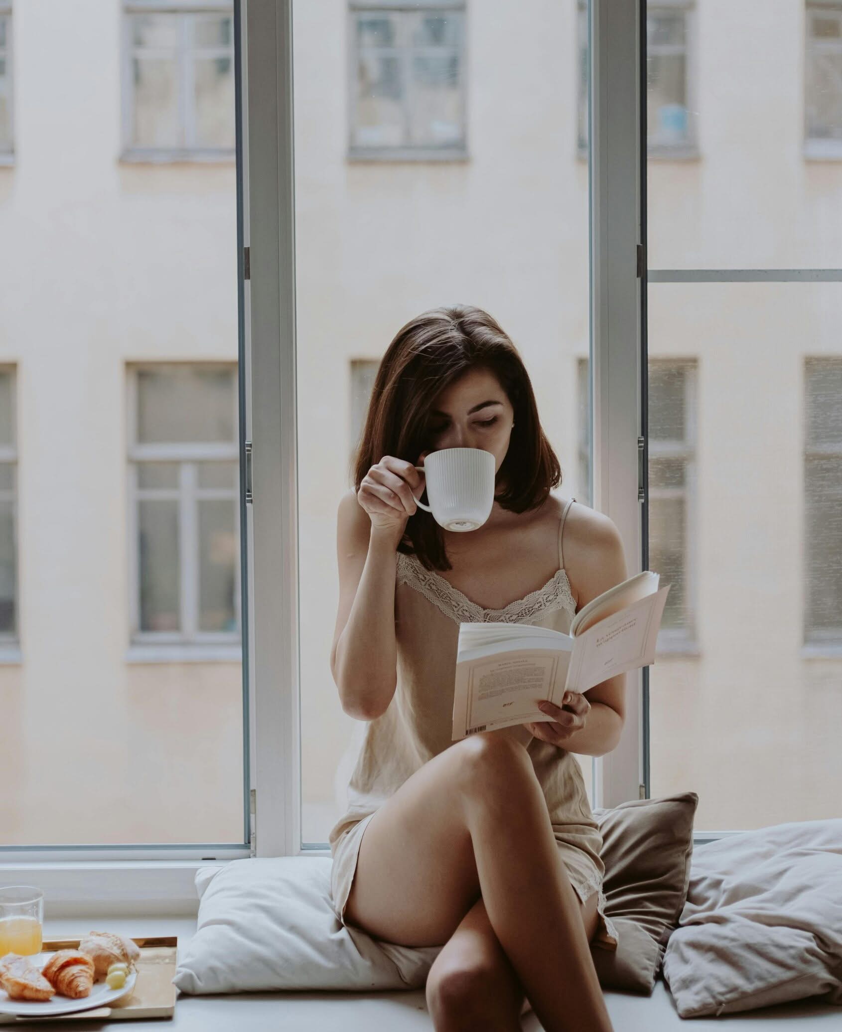 Woman relaxing at home with coffee and book in a clean, fresh space maintained by Brilliance Crew in San Francisco